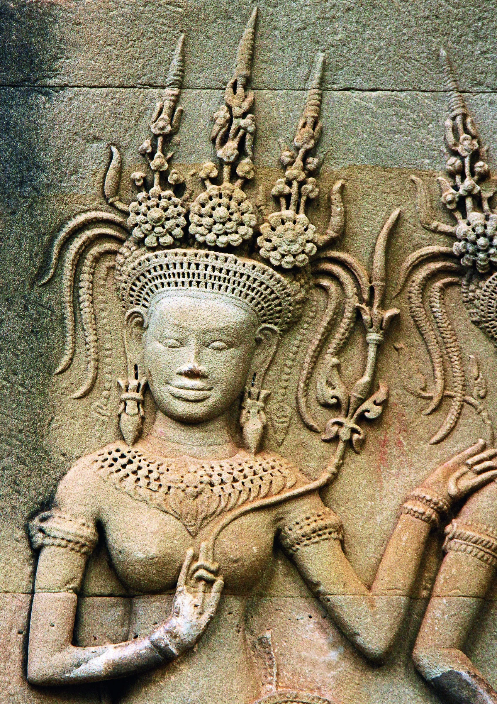 An intricately carved stone figure on the wall of an Angkor temple