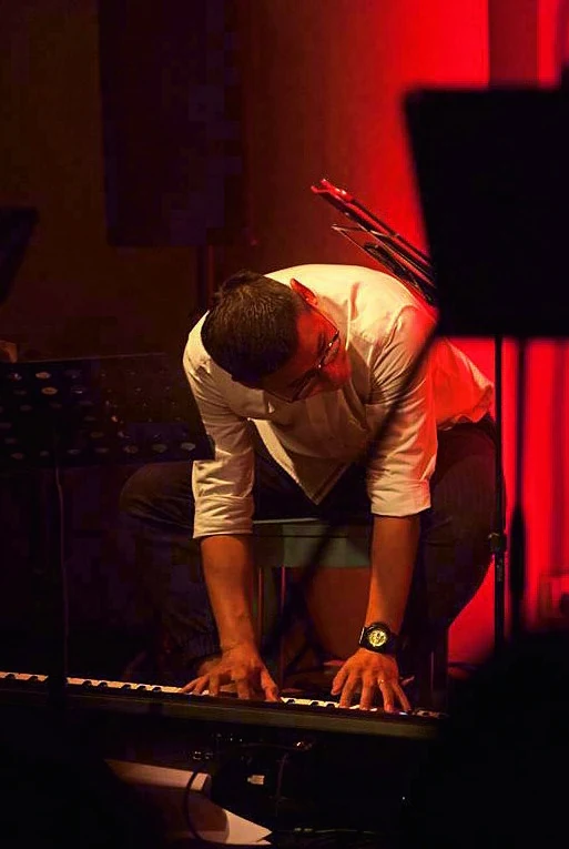 An unplanned moment on stage: Cher Siang keeps playing after his keyboard stand gives way.