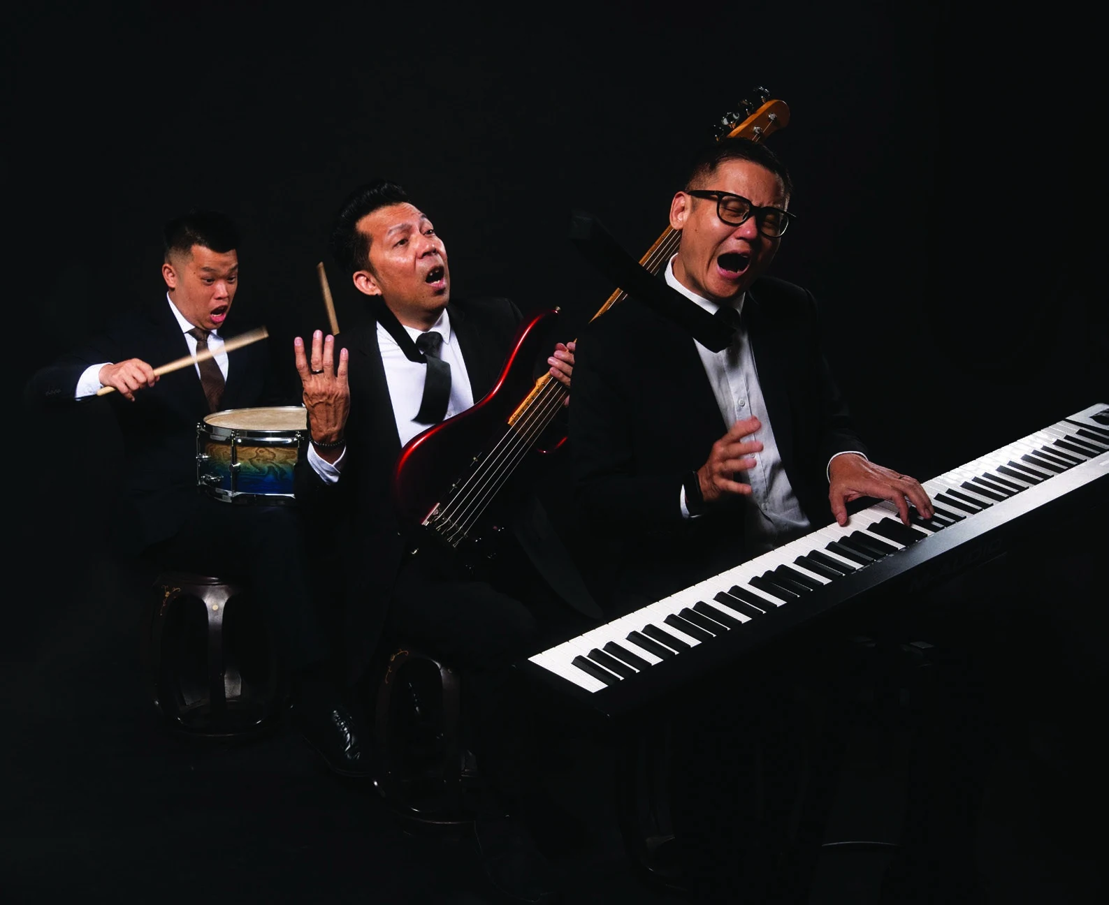 Tay Cher Siang and fellow musicians performing together against a dark stage background