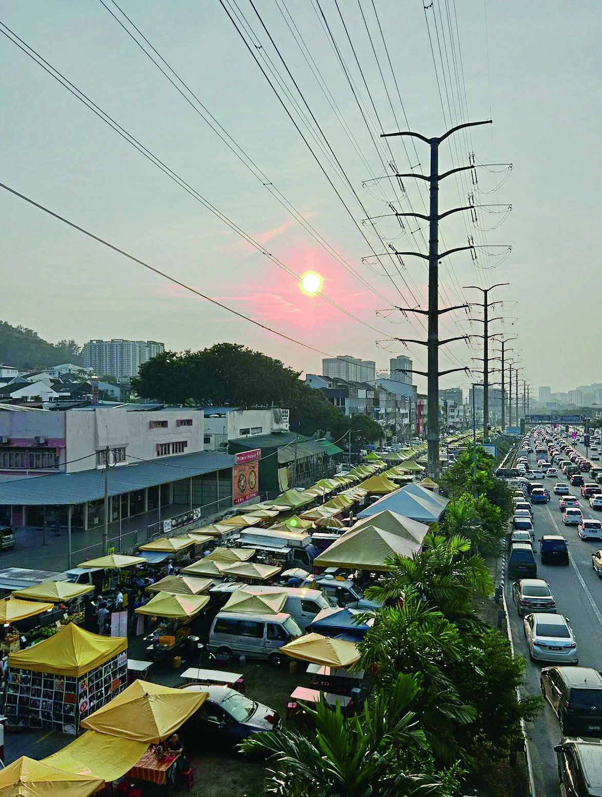 The neighbourhood shifts into its evening rhythm beneath the market canopies.